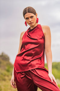 Woman wearing the Kiri Top sewing pattern from Fibre Mood on The Fold Line. A sleeveless top pattern made in satin, acetate, charmeuse, silk, viscose (crepe), lyocell, or chambray fabric, featuring a halter neck, draped front, and asymmetrical hem.