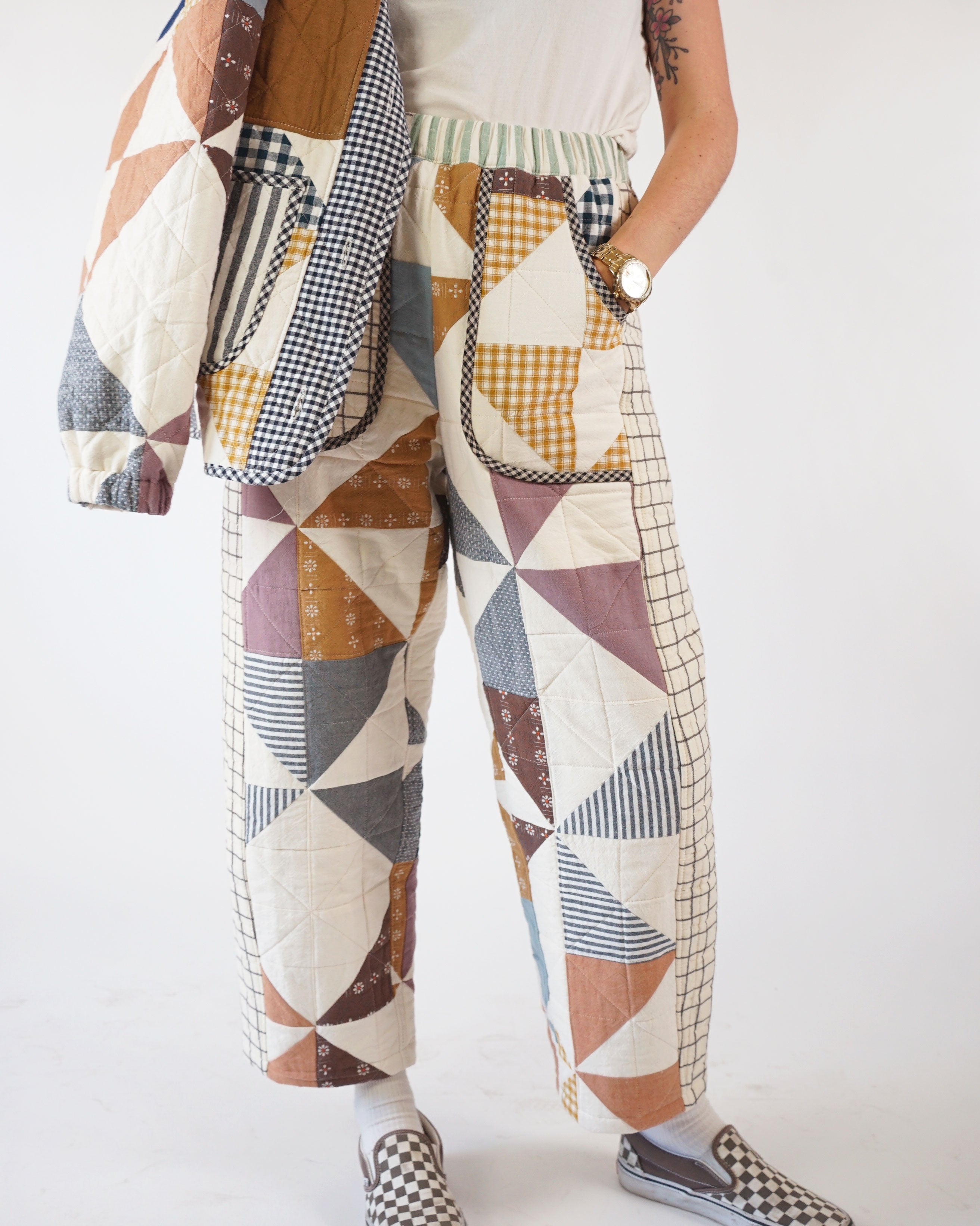 Woman wearing the Kite Pants sewing pattern from Matchy Matchy Sewing Club on The Fold Line. A trousers pattern made in cotton, linen, twill, canvas, or denim fabric, featuring a relaxed fit, high waist, subtly curved leg, side inset detail, two front pockets, two back pockets, quilting, and ankle length.