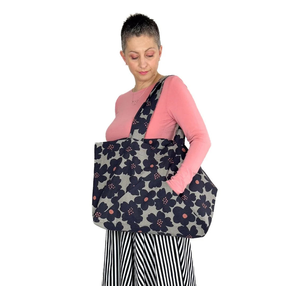 Woman carrying the Kulmi Bag sewing pattern from Dhurata Davies Patterns on The Fold Line. A tote bag pattern made in canvas, cotton twill, denim, or linen fabric, featuring interior and exterior pockets and a full lining.