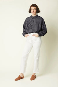 Woman wearing the La Chemise sewing pattern from Atelier Brunette on The Fold Line. A shirt pattern made in viscose, cotton-linen blend, or corduroy fabric, featuring an oversized cut, collar, front button placket, and batwing sleeves with two-button sleeve cuffs.