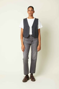 Woman wearing the La Petite Veste sewing pattern from Atelier Brunette on The Fold Line. A waistcoat pattern made in corduroy, gabardine, linen, or linen-cotton blend fabric, featuring a wide cut, angular details, and patch pockets.
