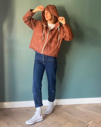Woman wearing the Laken Jacket sewing pattern from French Navy on The Fold Line. A jacket pattern made in corduroy, linen, denim, cotton twill, wool, or wool blend fabric, featuring a boxy fit, dropped shoulder, front zipper, drawstring hood, and patch pockets with flaps.