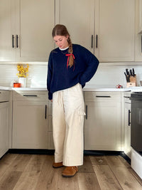 Woman wearing the Lane Pants sewing pattern from Syd Graham Patterns on The Fold Line. A trousers pattern made in cotton or linen fabric, featuring a relaxed fit, high waist, drawstring, wide leg, and cargo pockets.