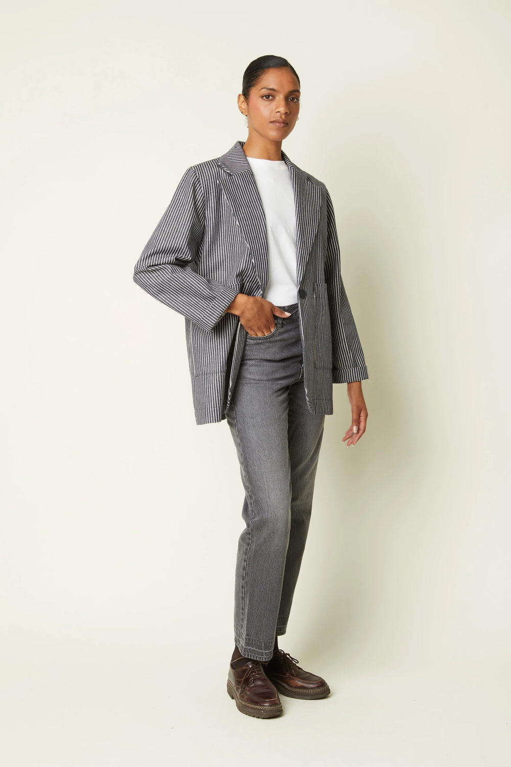 Woman wearing the Le Blazer sewing pattern from Atelier Brunette on The Fold Line. An unlined blazer pattern made in gabardine, cotton-linen twill, or jacquard fabric, featuring a slightly oversized cut, tailored collar, single button closure, and patch pockets.