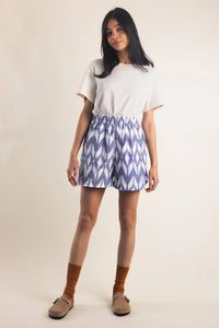 Woman wearing the Le Boxer sewing pattern from Atelier Brunette on The Fold Line. A shorts pattern made in cotton or cotton blend, poplin, ikat, viscose or viscose blend fabric, featuring an elasticated waistband, topstitched faux fly, and side seam pockets.