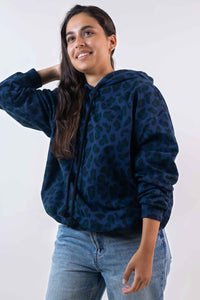 Woman wearing the Le Hoodie sewing pattern from Atelier Brunette on The Fold Line. A top pattern made in sweatshirt, jersey, knit, soft denim, or light gabardine fabric, featuring an oversized fit, long sleeves, and a hood.