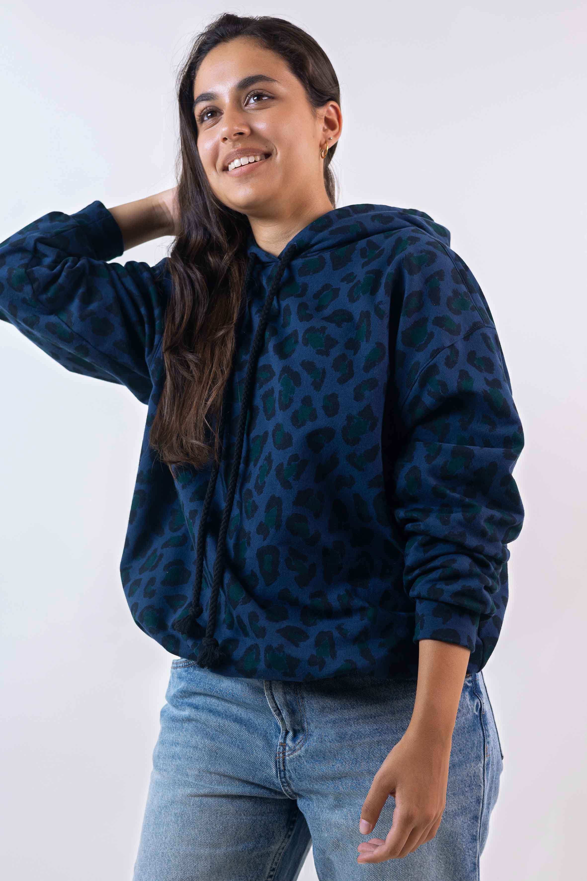 Woman wearing the Le Hoodie sewing pattern from Atelier Brunette on The Fold Line. A top pattern made in sweatshirt, jersey, knit, soft denim, or light gabardine fabric, featuring an oversized fit, long sleeves, and a hood.