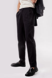 Woman wearing the Le Pantalon Carotte sewing pattern from Atelier Brunette on The Fold Line. A trousers pattern made in gabardine or cotton-linen twill fabric, featuring a tapered leg, zip fly, pleats, side pockets, and back patch pockets.