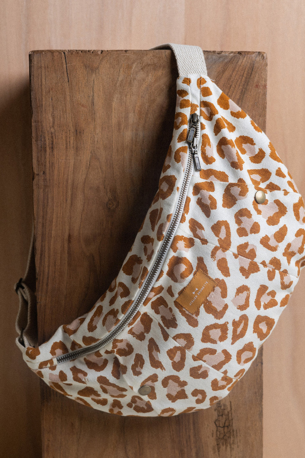 The Le Sac Banane sewing pattern from Atelier Brunette on The Fold Line. A lined bag pattern made in gabardine, cotton-linen twill, or corduroy fabric, featuring a double slider zipper closure, kangaroo pocket with press button closures, zipper pocket, and webbing strap.