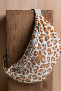 The Le Sac Banane sewing pattern from Atelier Brunette on The Fold Line. A lined bag pattern made in gabardine, cotton-linen twill, or corduroy fabric, featuring a double slider zipper closure, kangaroo pocket with press button closures, zipper pocket, and webbing strap.