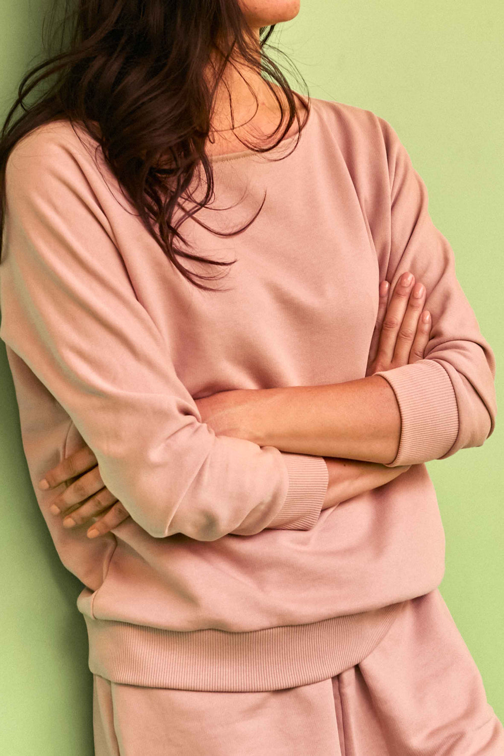 Woman wearing the Le Sweat sewing pattern from Atelier Brunette on The Fold Line. A top pattern made in sweatshirt, French terry, jersey, cotton, or viscose fabric, featuring a boat neck, long sleeves, and ribbing at the cuffs and hem. 