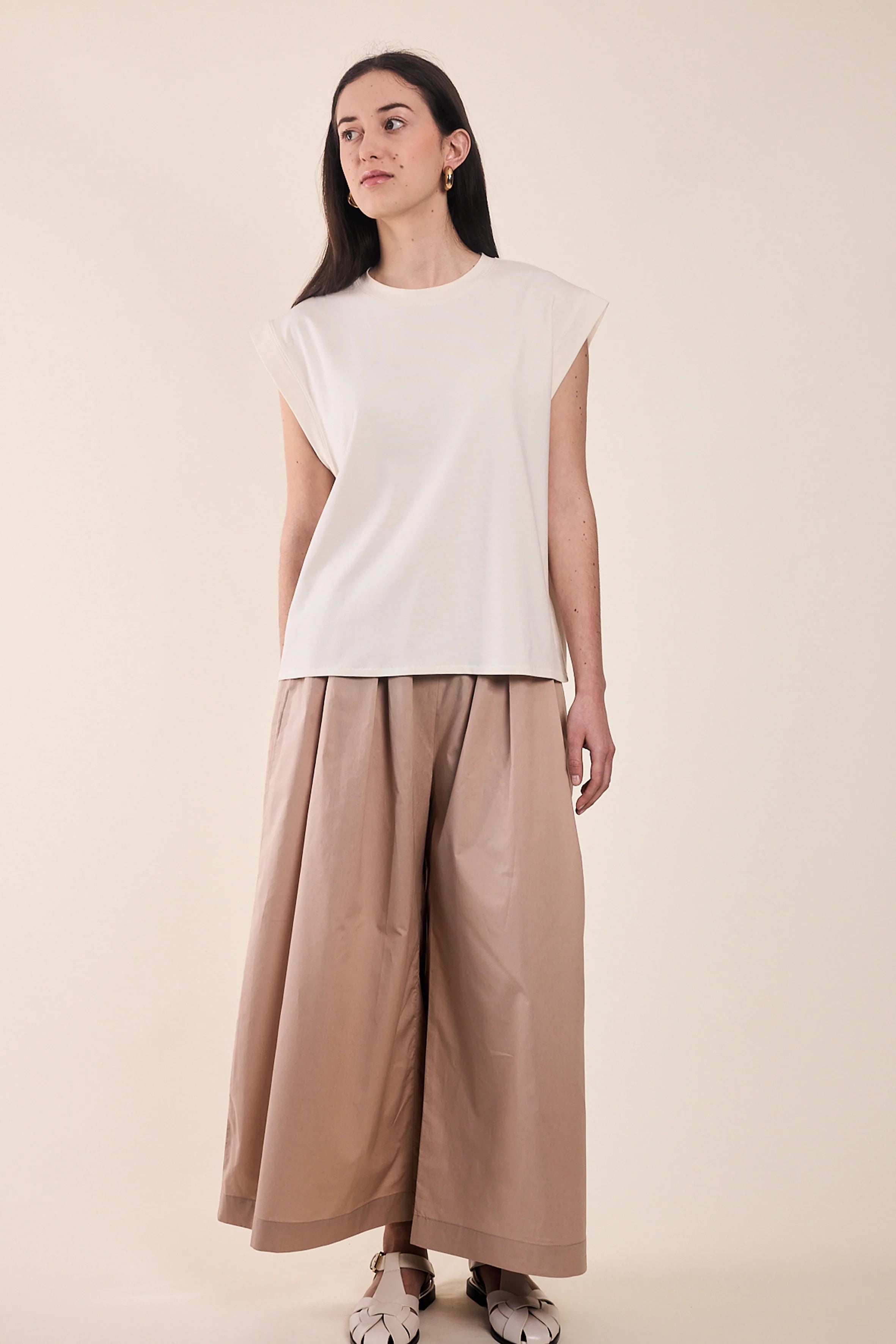 Woman wearing the Le T-Shirt sewing pattern from Atelier Brunette on The Fold Line. A sleeveless top pattern made in modal jersey or cotton jersey fabric, featuring a relaxed fit, round neckline, and wide armholes.