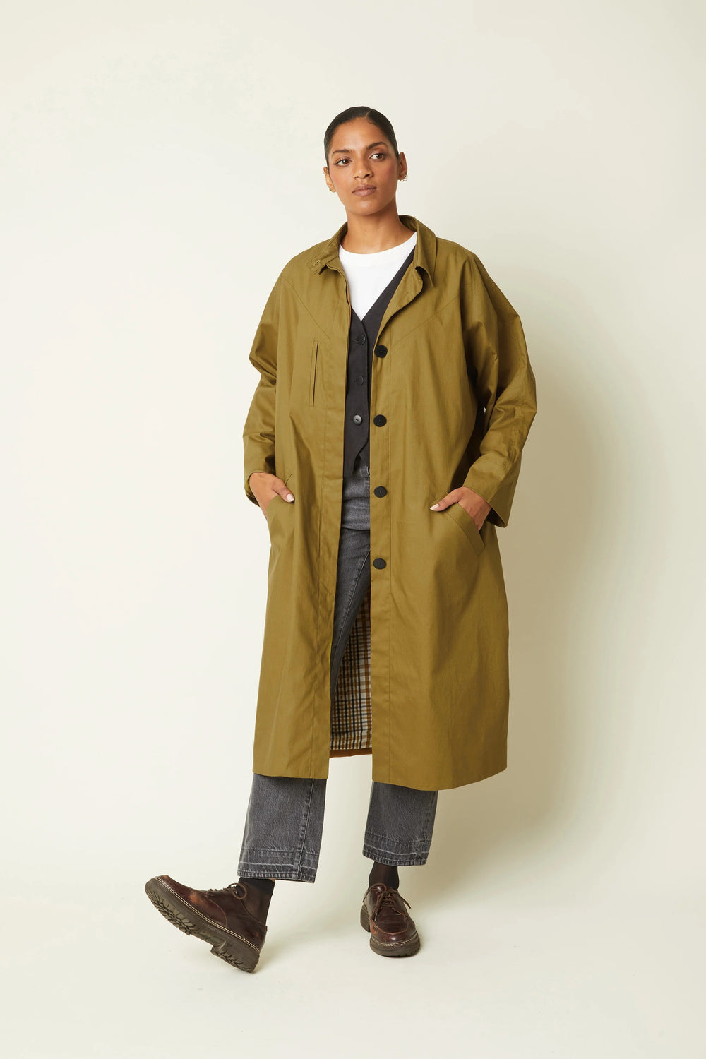 Woman wearing the Le Trench sewing pattern from Atelier Brunette on The Fold Line. A lined trench coat pattern made in gabardine fabric, featuring an oversized fit, collar and stand, hidden button placket, raglan sleeves, and welt pockets.