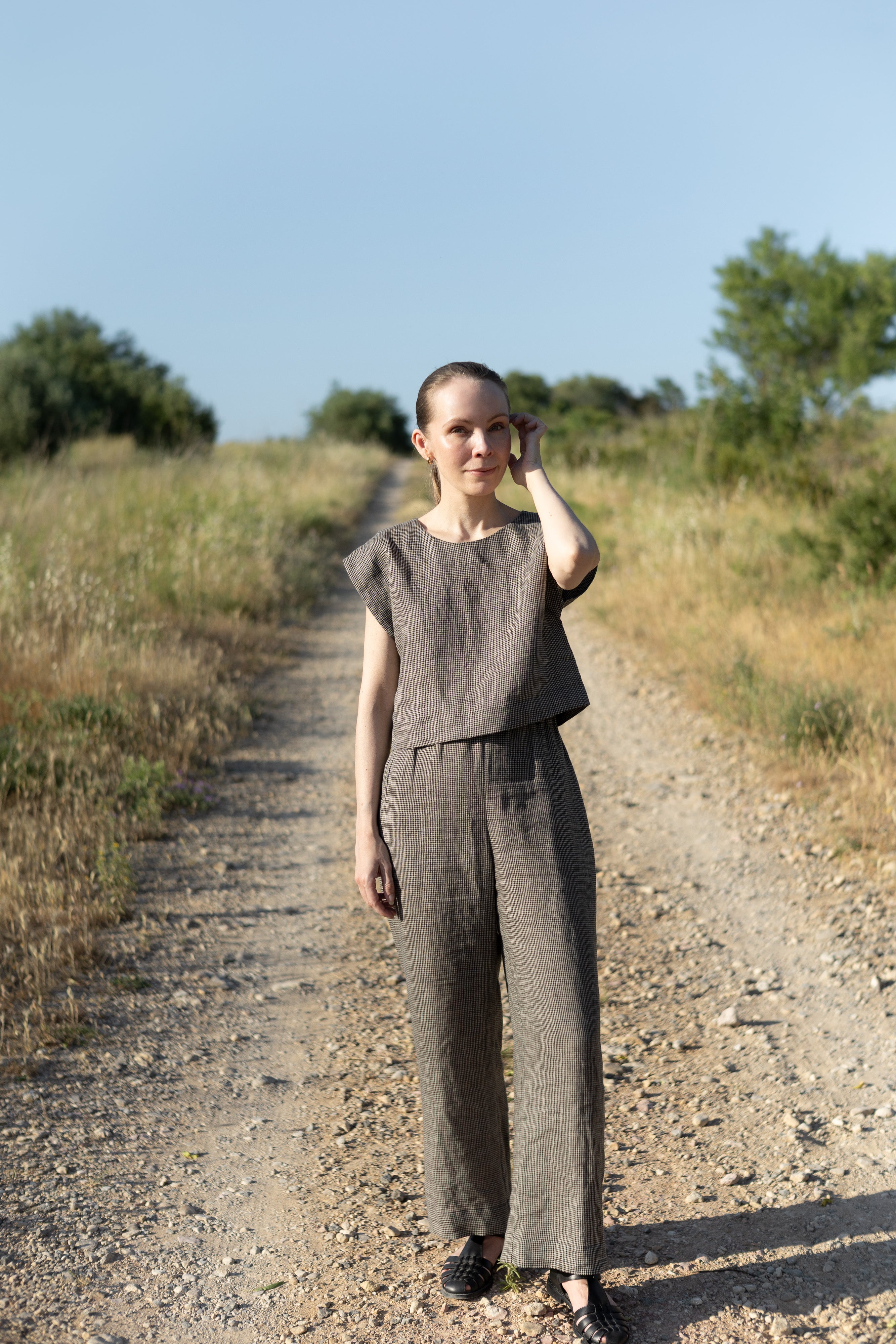 Woman wearing the Lea Top and Pants sewing pattern from Silversaga Patterns on The Fold Line. A top and trousers pattern made in linen, hemp, soft cottons, cotton block prints, linen blends, tencel twill, or rayon/viscose fabric, featuring a top with a round neckline and grown-on short sleeves, and trousers with a high elasticated waist and in-seam pockets.