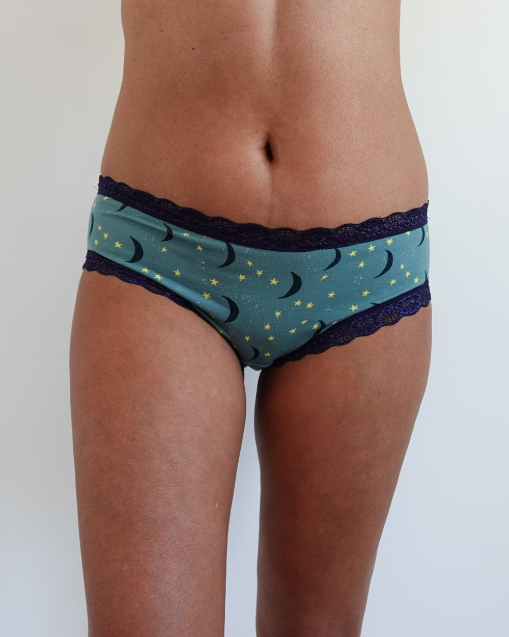 Woman wearing the Lila Panties sewing pattern from Tammy Handmade on The Fold Line. An underwear pattern made in lightweight knit fabric, featuring stretch lace trim at the waist and leg openings.