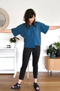Woman wearing the Lindon Top sewing pattern from In the Folds on The Fold Line. A top pattern made in viscose/rayon, silk, cotton lawn, voile, crepe, georgette, chiffon, or jersey knit fabric, featuring an oversized silhouette, dropped shoulder, mid-length sleeve, and asymmetric panel.