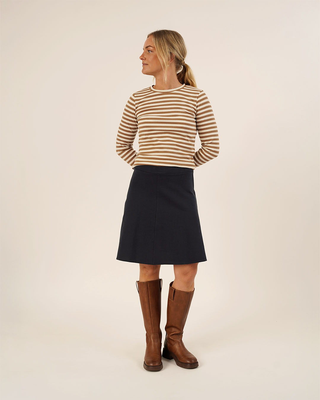 Woman wearing the Linea A-line Skirt sewing pattern from Wardrobe by Me on The Fold Line. A skirt pattern made in knit fabric, featuring an elastic waist and knee length.