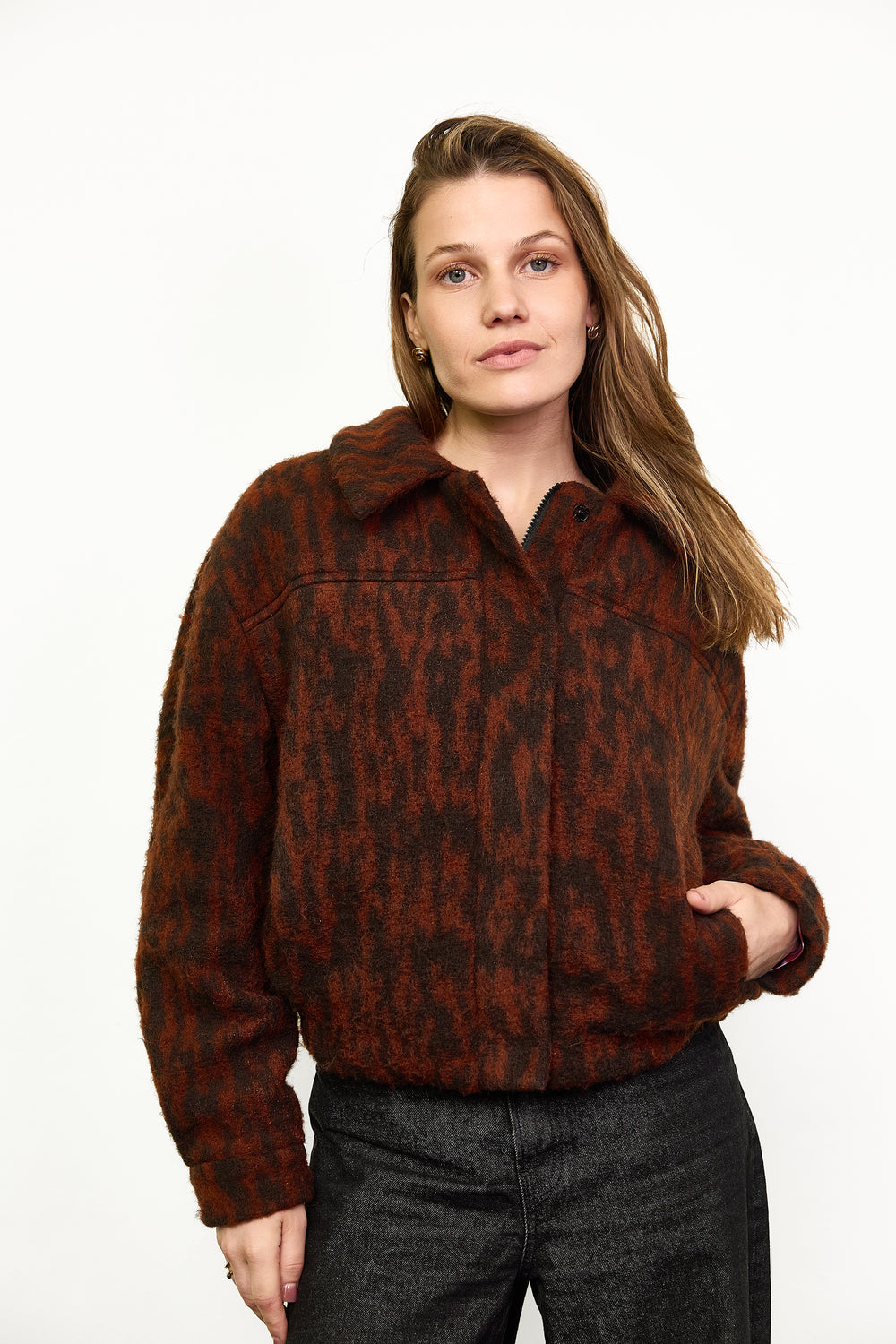 Woman wearing the Louise Jacket sewing pattern from Atelier Jupe on The Fold Line. A fully lined jacket pattern made in wool, wool blend, teddy fabric, corduroy, cotton, or quilted fabric, featuring a one-piece collar, zipper, snap placket, front and back yokes, pockets, and elastic at the hem.