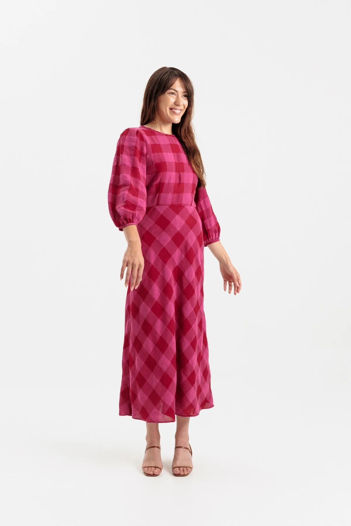 Woman wearing the Lulee Dress sewing pattern from Papercut Patterns on The Fold Line. A dress pattern made in cotton, linen, silk, or rayon fabric, featuring a round neck, darted bodice, long gathered sleeve, and hip skimming bias cut skirt. 