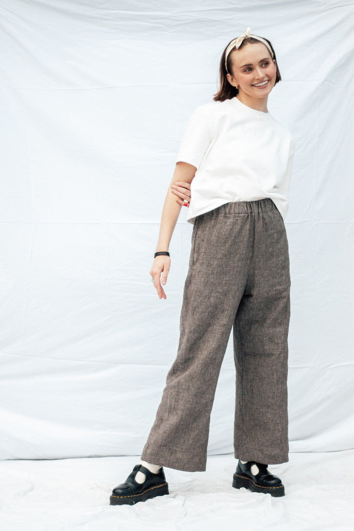 Woman wearing the MADE-line Pants sewing pattern from Madswick on The Fold Line. A pants pattern made in linen, viscose, tencel, denim, cotton lawn, cotton poplin, quilting cotton, or cotton twill fabric, featuring a high waist with a wide elastic waistband, in-seam pockets, a straight leg, and wide hem.