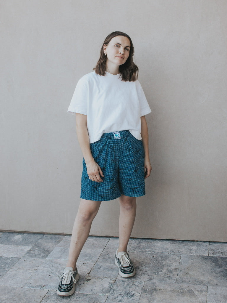 Woman wearing the MADE-line Shorts sewing pattern from Madswick on The Fold Line. A shorts pattern made in linen, viscose, tencel, denim, cotton lawn, cotton poplin, quilting cotton, or cotton twill fabric, featuring a grown-on elastic waistband, wide legs, and in-seam pockets.