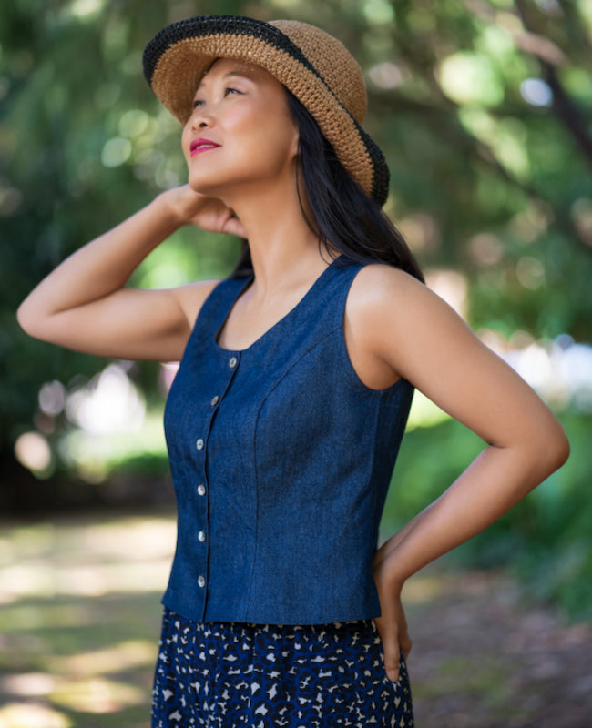 Woman wearing the Madalena Vest Top sewing pattern from Itch to Stitch on The Fold Line. A sleeveless top pattern made in linen, linen blend, twill or broadcloth fabric, featuring a wide scoop neckline, princess seams, and button front.