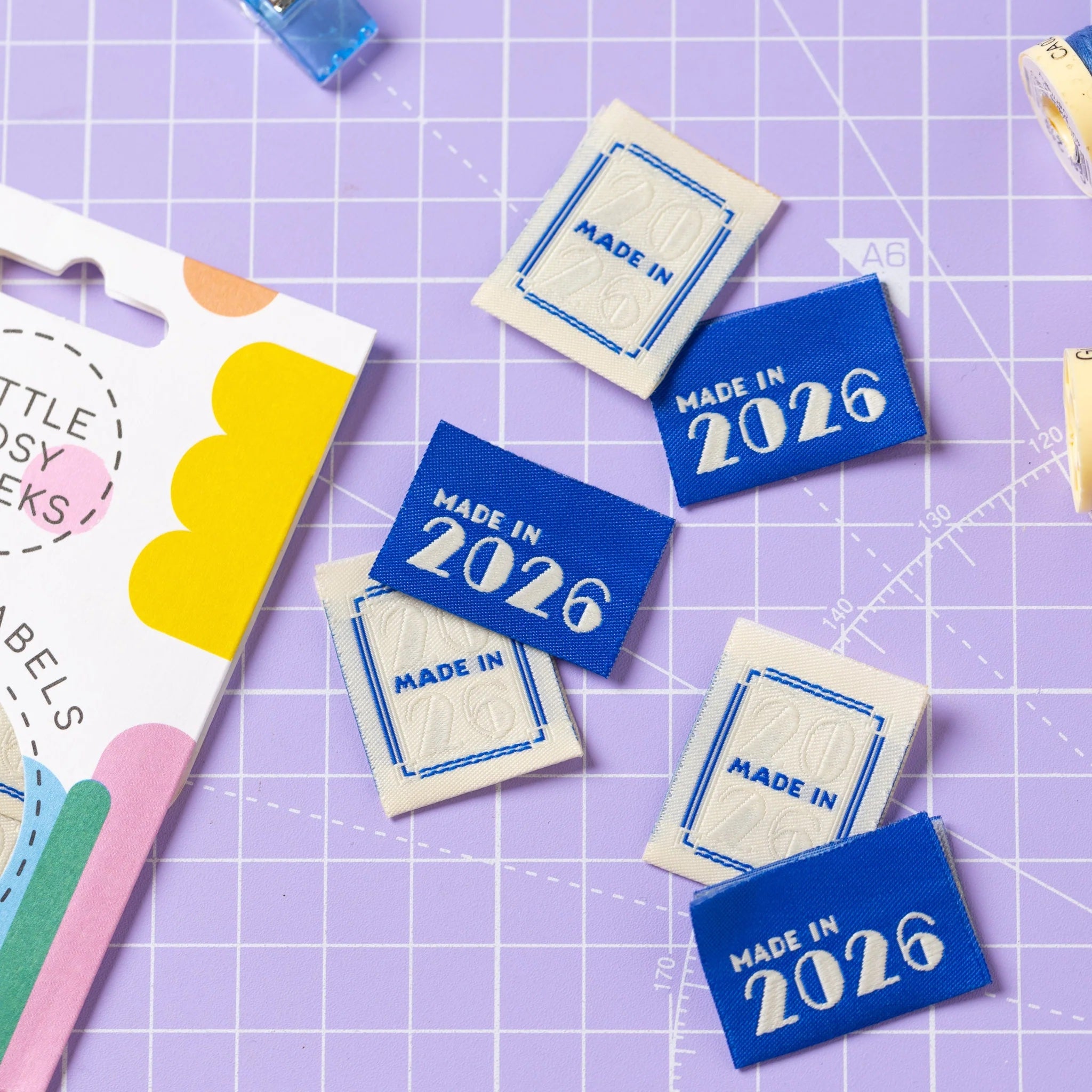 The 'Made in 2026' woven labels from Little Rosy Cheeks on The Fold Line. The pack includes 6 embossed labels with an ecru or blue background, ready to be sewn into your handmade clothes.
