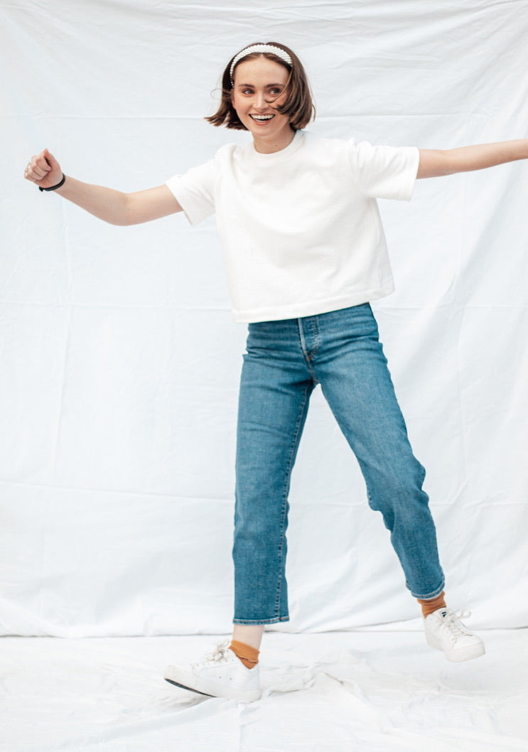 Woman wearing the Madeline Tee sewing pattern from Madswick on The Fold Line. A T-shirt pattern made in knit fabric such as French terry, ponte, rib, jersey, fleece, modal, or waffle fabric, featuring a boxy fit, round neck, slightly dropped shoulders, and short sleeves.