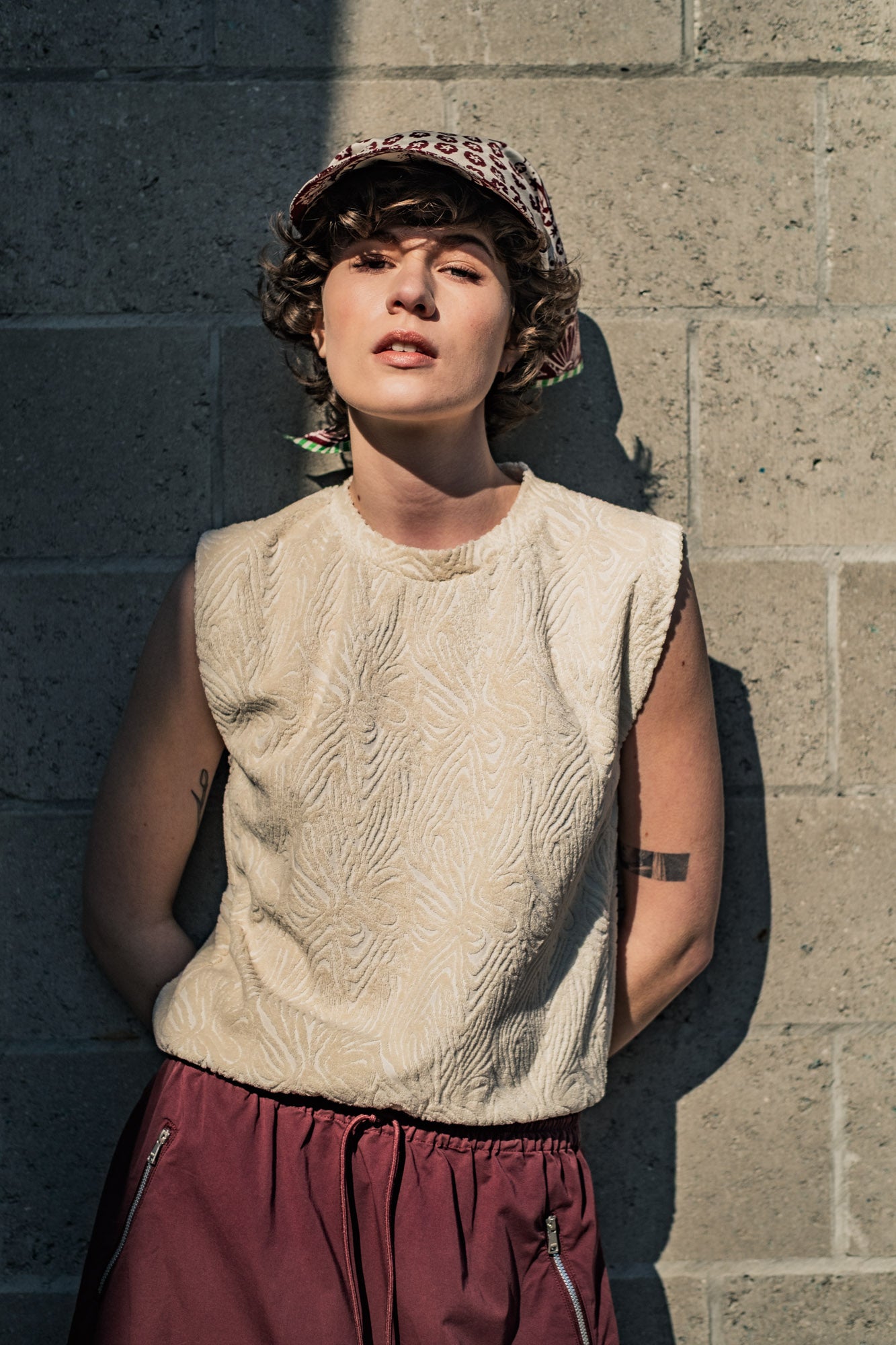 Woman wearing the Maela Top sewing pattern from Fibre Mood on The Fold Line. A sleeveless top pattern made in knit or sheer fabric, featuring a relaxed fit and round neckline.