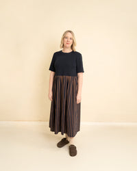 Woman wearing the Maize Dress sewing pattern from Little Rosy Cheeks on The Fold Line. A dress pattern made in knit and cotton lawn, cotton poplin, denim chambray, linen, or viscose fabric, featuring a round neckline, short sleeves, gathered skirt, patch pockets, and maxi length.