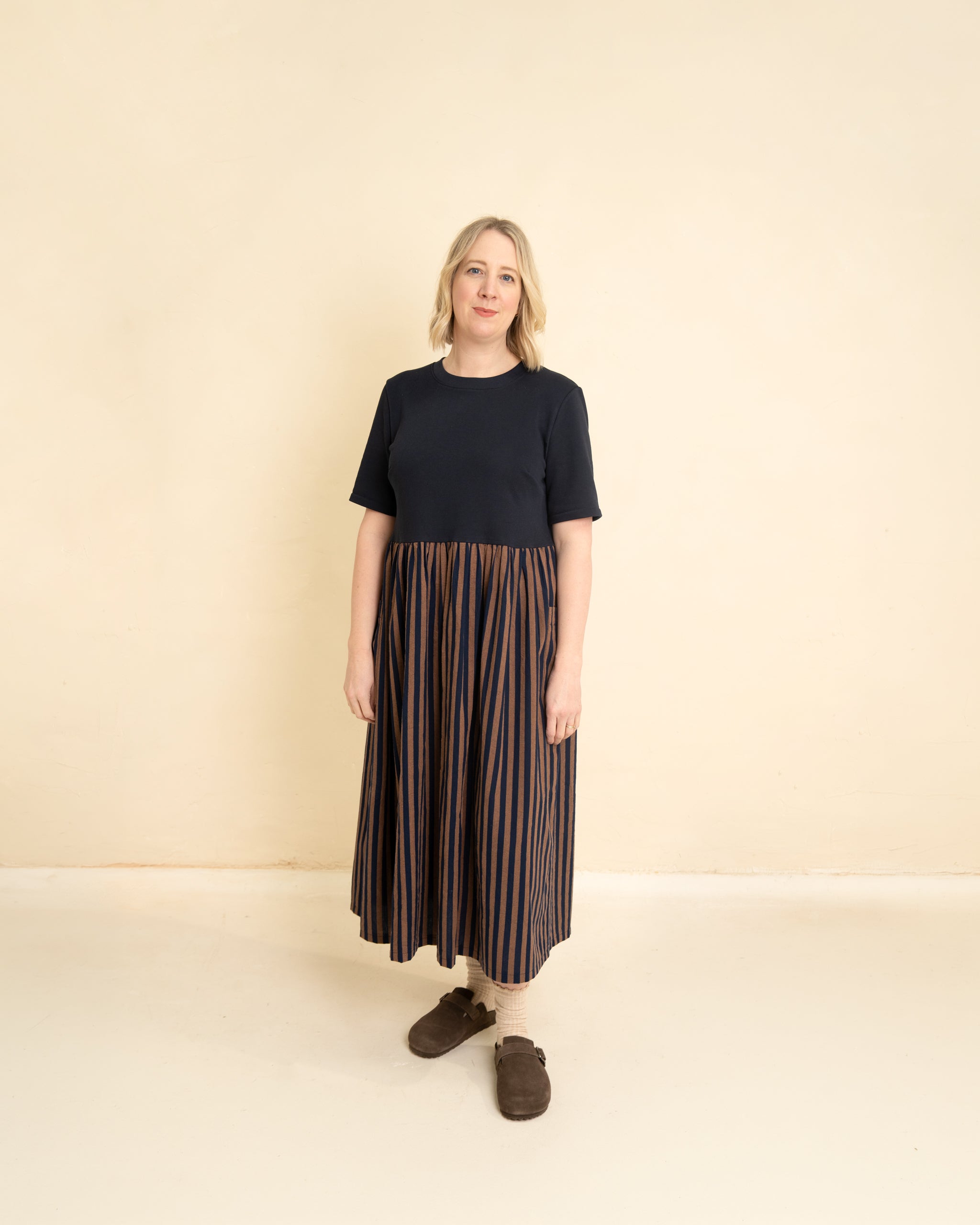 Woman wearing the Maize Dress sewing pattern from Little Rosy Cheeks on The Fold Line. A dress pattern made in knit and cotton lawn, cotton poplin, denim chambray, linen, or viscose fabric, featuring a round neckline, short sleeves, gathered skirt, patch pockets, and maxi length.