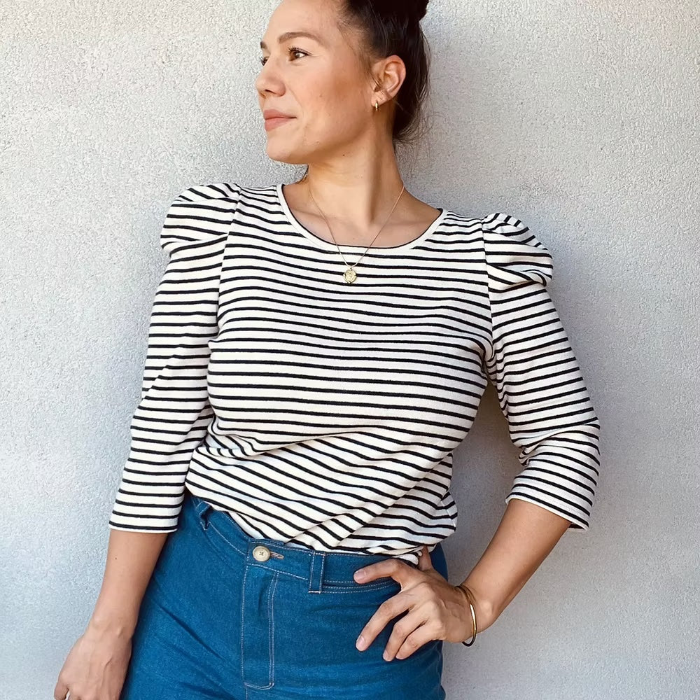 Woman wearing the Mara Top sewing pattern from Sew.lala Patterns on The Fold Line. A knit top pattern made in jersey, punto, terry or sweatshirt fabric, featuring a round neckline and 3/4 length puff sleeves.