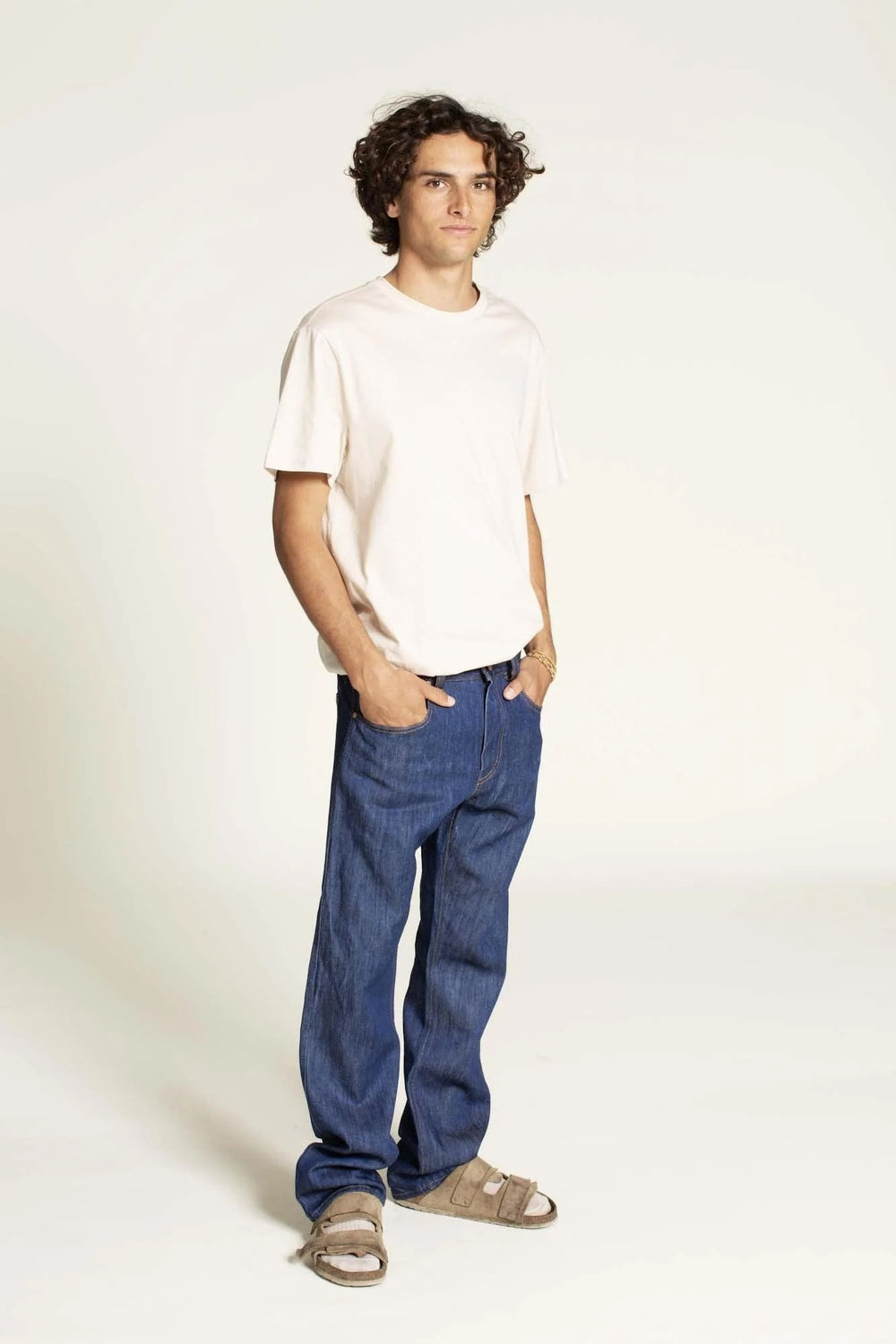 Man wearing the Men's Jeans sewing pattern from Wardrobe by Me on The Fold Line. A jeans pattern made in non-stretch denim or canvas fabric, featuring a relaxed fit, straight leg, front fly with zipper, back yoke, and classic five-pocket styling.