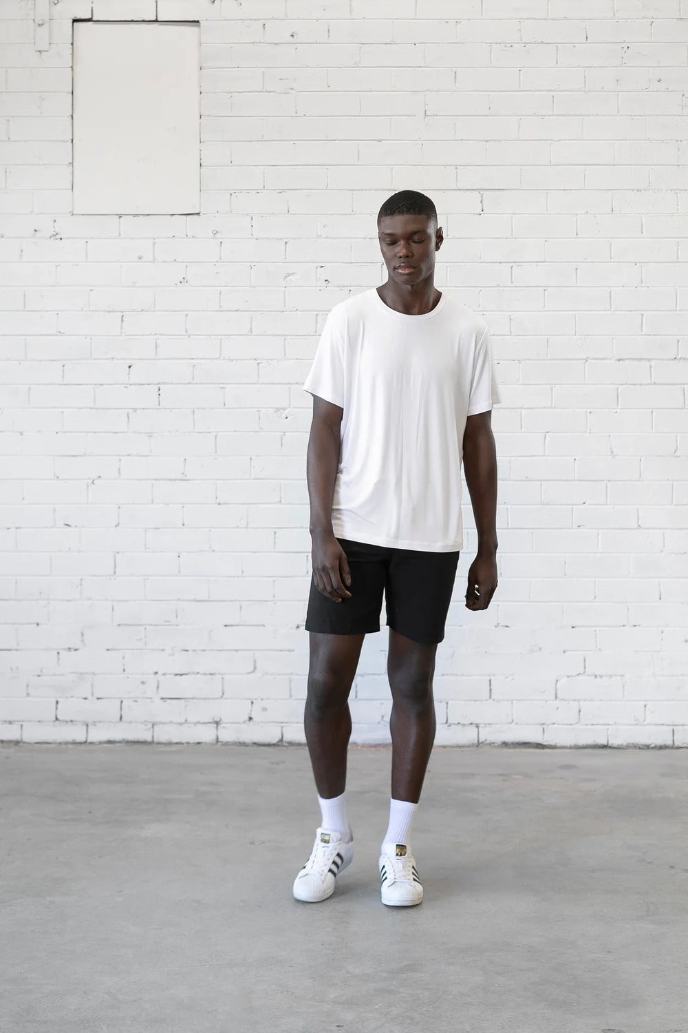 Man wearing the Men's Sage Tee sewing pattern from Elbe Textiles on The Fold Line. A T-shirt pattern made in knit fabric, featuring a relaxed fit, crew neck, and short sleeves.