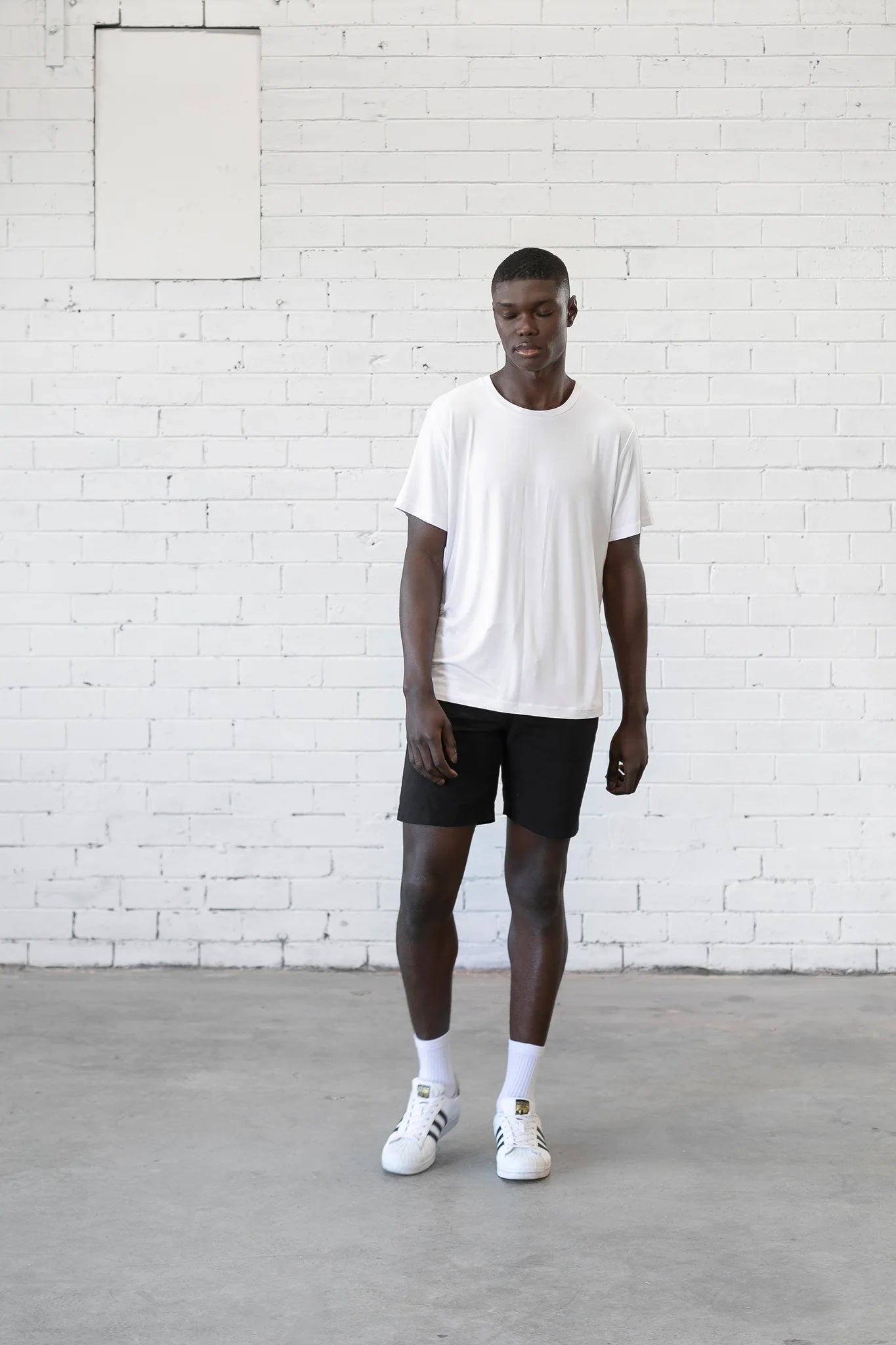 Man wearing the Men's Sage Tee sewing pattern from Elbe Textiles on The Fold Line. A T-shirt pattern made in knit fabric, featuring a relaxed fit, crew neck, and short sleeves.