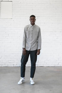 Man wearing the Men's Sanders Button Up sewing pattern from Elbe Textiles on The Fold Line. A shirt pattern made in soft cotton shirting, washed linen, woven hemp blends, lightweight denim, or flannelette fabric, featuring a semi-fitted shape, collar, front yoke with in-seam pockets, button front, and long sleeves with cuffs.