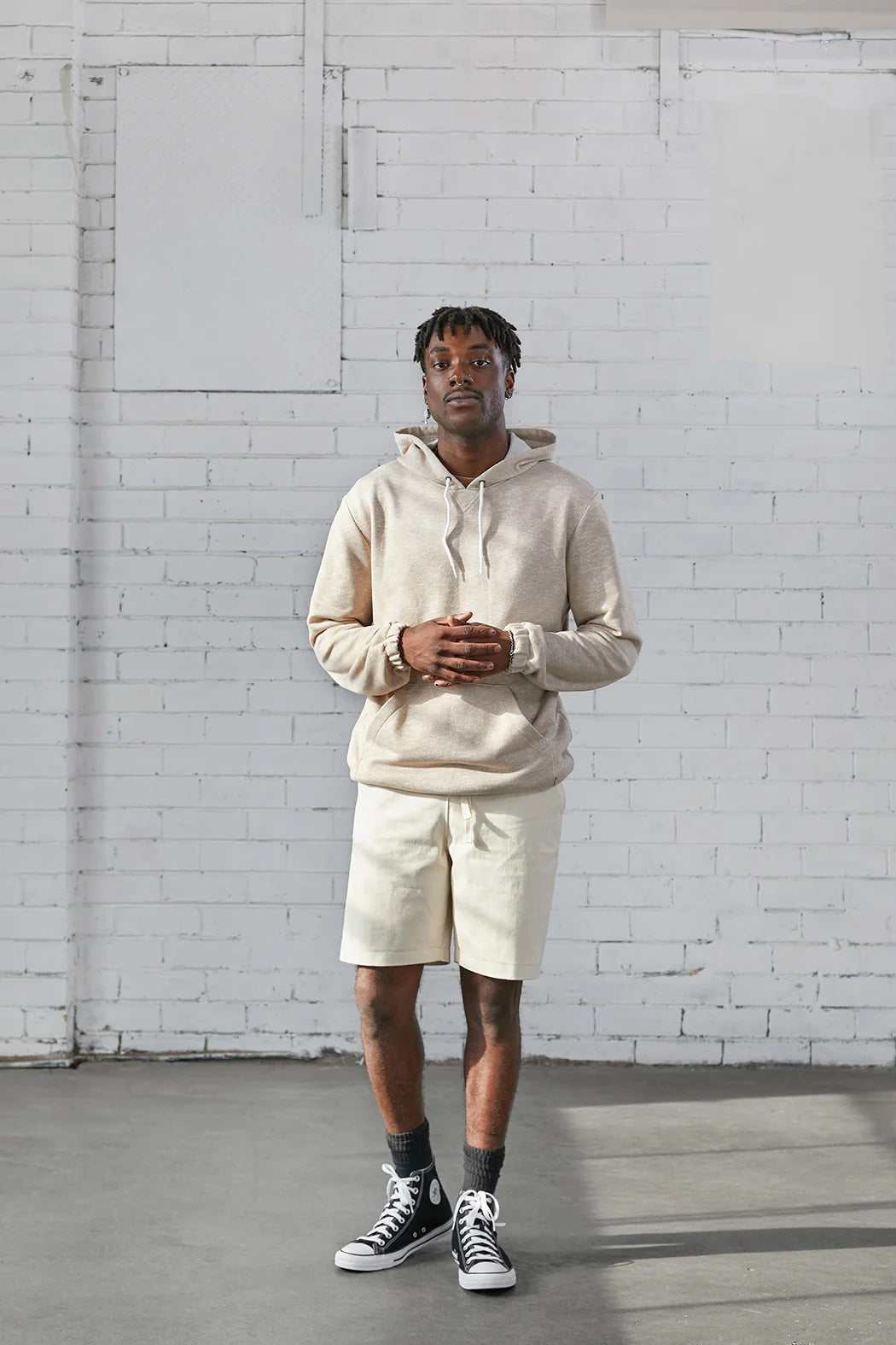 Man wearing the Men's Smith Hoodie sewing pattern from Elbe Textiles on The Fold Line. A hoodie pattern made in sweatshirt material, french terry, or knit fabric, featuring a drawstring hood, kangaroo pocket, and elasticated cuffs and hem.