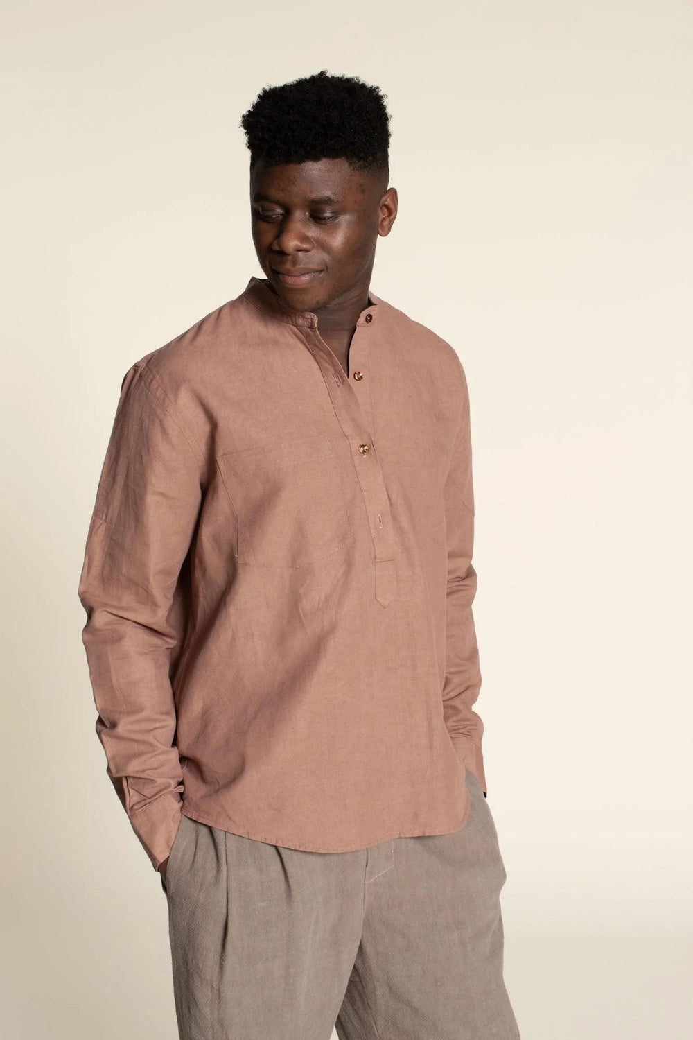 Man wearing the Men’s Tunic sewing pattern from Wardrobe by Me on The Fold Line. A shirt pattern made in cotton oxford, poplin, denim, flannel, linen, or silk fabric, featuring a band collar, half placket, chest pocket, and long sleeves.