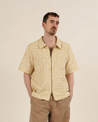 Man wearing the Men's Zip Shirt sewing pattern from Wardrobe by Me on The Fold Line. A shirt pattern made in denim, corduroy, or poplin fabric, featuring a full front zipper, set-in collar, front patch pocket, and short sleeves.