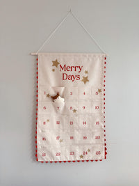 The Merry Days Advent Calendar sewing pattern from Me & Kiddo Patterns on The Fold Line. An advent calendar pattern made in cotton, cotton canvas, or linen fabric, featuring 25 pockets and a mini stuffed reindeer that moves from pocket to pocket.