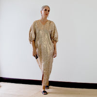 Woman wearing the Mersis Dress sewing pattern from Pattern Fantastique on The Fold Line. A dress pattern made in soft cotton, poplin, drapey linen, silk twill, rayon, or tencel fabric, featuring front and back V-necklines, voluminous elbow length sleeves, a front split, and maxi length.