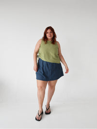 Woman wearing the Mesa Top sewing pattern from Les Perlines on The Fold Line. A sleeveless top pattern made in cotton, linen, rayon, viscose, or tencel twill fabric, featuring an adjustable side drawstring that creates soft gathers and an asymmetrical silhouette.