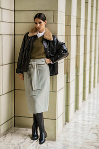 Woman wearing the Mireya Skirt sewing pattern from Fibre Mood on The Fold Line. A lined skirt pattern made in wool, double crepe, or soft twill fabric, featuring sleeves that tie at the front, an invisible zipper, back vent, and knee length. 