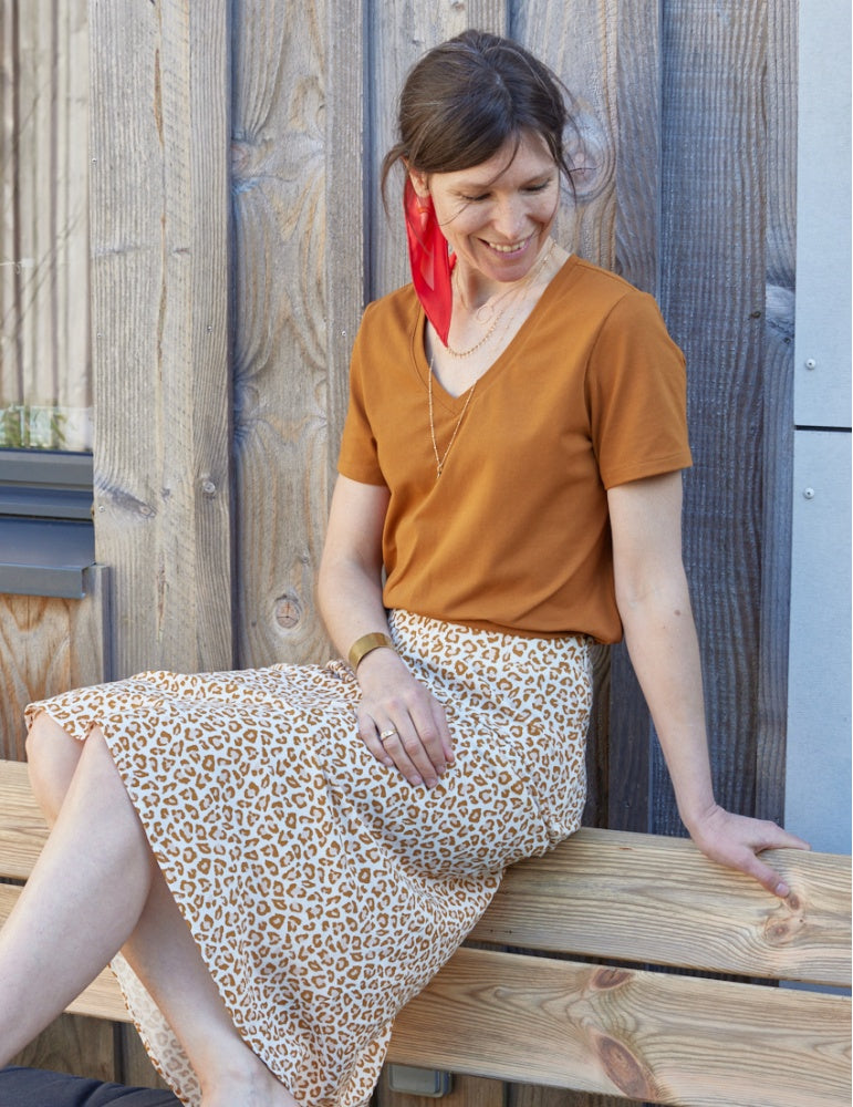 Woman wearing the Modjo T-shirt sewing pattern from Atelier Scämmit on The Fold Line. A T-shirt pattern made in knit fabric, featuring a relaxed fit, V-neck, and short sleeves.