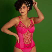 Woman wearing the Monet Merry Widow Corset sewing pattern from Madalynne on The Fold Line. A corset and panty pattern made in lace and satin, coutil, or lycra fabric, featuring a corset with a semi-sheer lace panel in the centre front, 3-part bra cups, and a figure-hugging fit, and a matching thong with a lace insert on the front, wide elastic at the waistline, and fold over elastic on the leg openings.