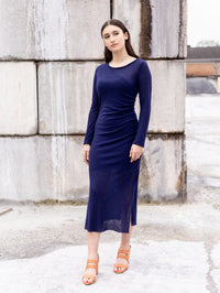Woman wearing the Moriko Dress sewing pattern from Notches on The Fold Line. A dress pattern made in jersey, French terry, punta di roma, or stretch woven fabric, featuring a round neck, long sleeves, gathered side seam, side slits, and midi length.