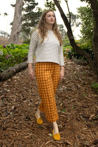 Woman wearing the Morris Pants sewing pattern from Christine Haynes on The Fold Line. A trousers pattern made in linen, twill, lightweight canvas, wool, baby wale corduroy, or denim fabric, featuring a high fitted waist, narrow waistband with button tab, lapped side zipper, back welt pockets, and slightly tapered and cropped legs with a side split vent.