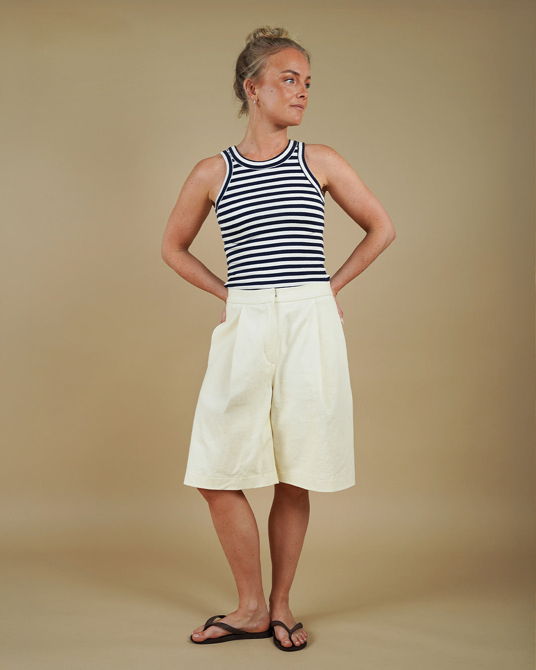 Woman wearing the Muscle Tank Top sewing pattern from Wardrobe by Me on The Fold Line. A tank top pattern made in jersey knit fabric, featuring a fitted silhouette, high round neckline, scooped armholes, and wide binding.
