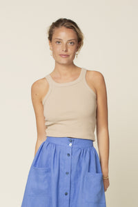 Woman wearing the Muscle Tank Top sewing pattern from Wardrobe by Me on The Fold Line. A tank top pattern made in jersey knit fabric, featuring a fitted silhouette, high round neckline, scooped armholes, and wide binding.