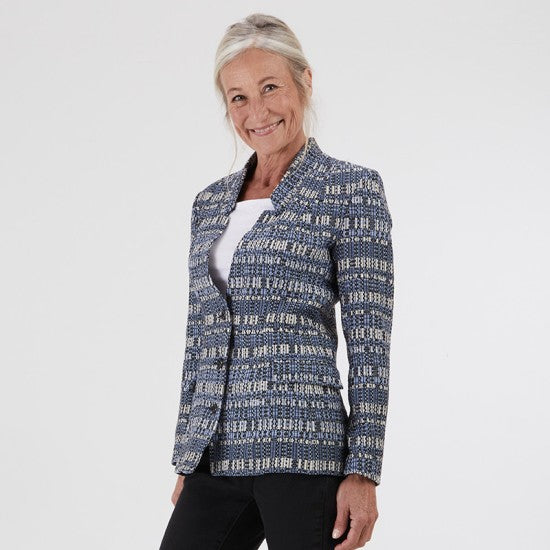 Woman wearing the Naïade Jacket sewing pattern from Coralie Bijasson on The Fold Line. A lined blazer pattern made in cotton satin, cotton piqué, denim, wool, gabardine, or jacquard fabric, featuring a tailored fit, princess seams, raised shawl collar, welt pockets with flaps, and hip length.